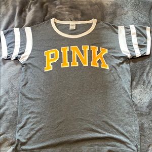 grey shirt with golden yellow writing